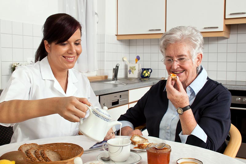 Photo of home care nurse making breakfast for a patient